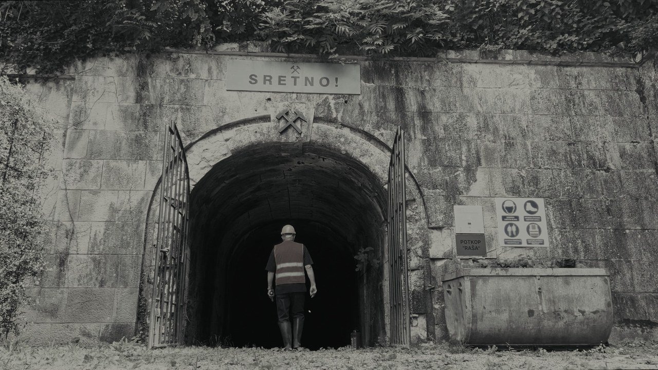 A worker entering the Raša mine beneath the word Sretno
