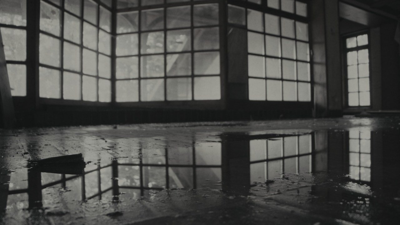 An abandoned hall reflected in standing water