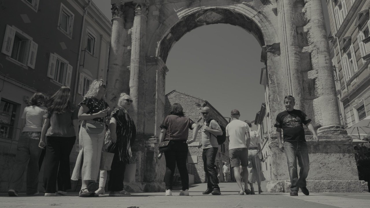 Tourists beneath the Arch of the Sergii in Pula